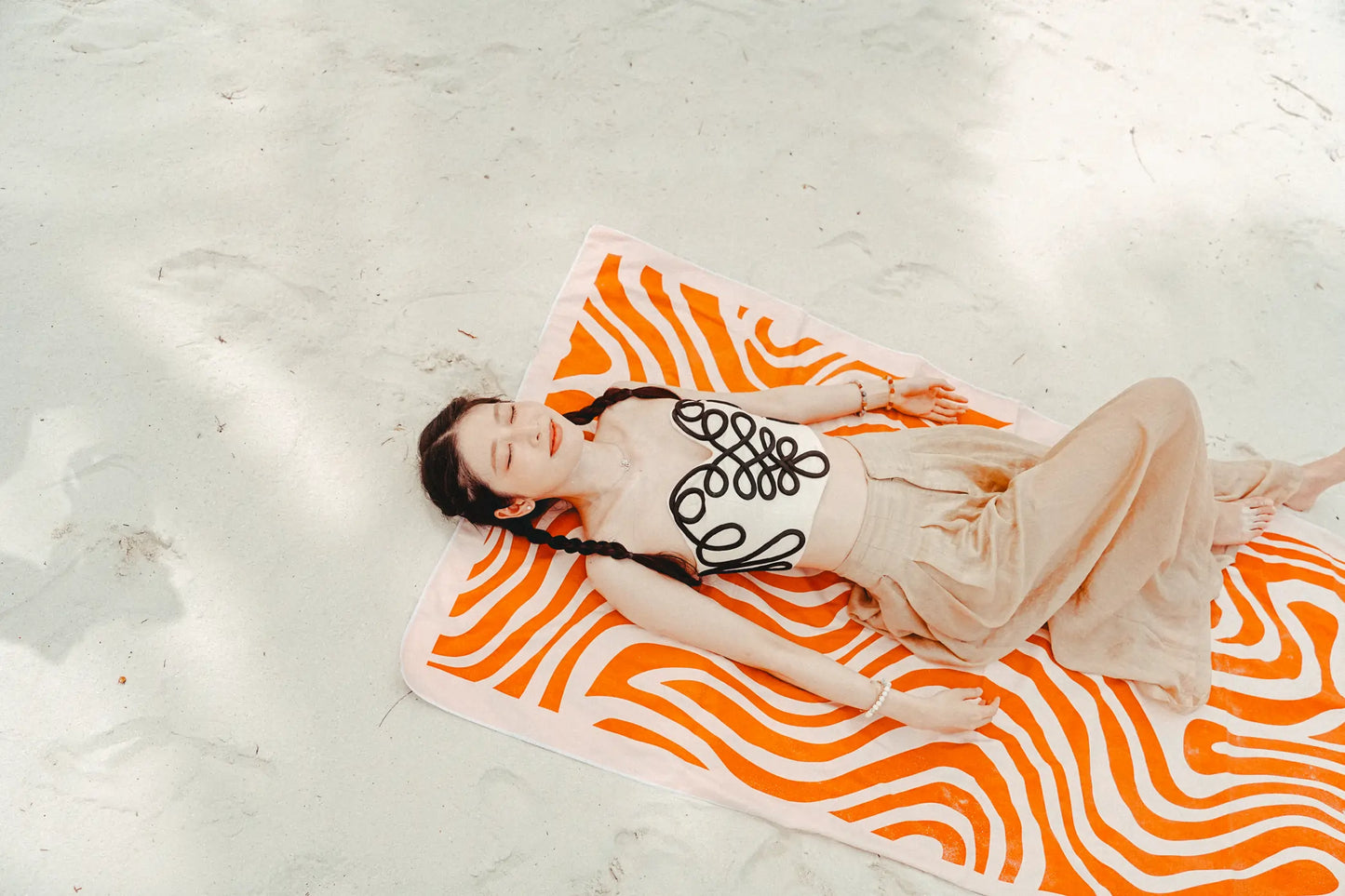 Coralia & Co. 2-in-1 Beach Towel Backpack - Coral Waves in coral orange and white, side view with sand-free design