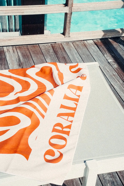 Coralia & Co. Large Quick Dry Microfiber Beach Towel - Ocean Breeze in white and orange, showing 2-in-1 backpack conversion feature